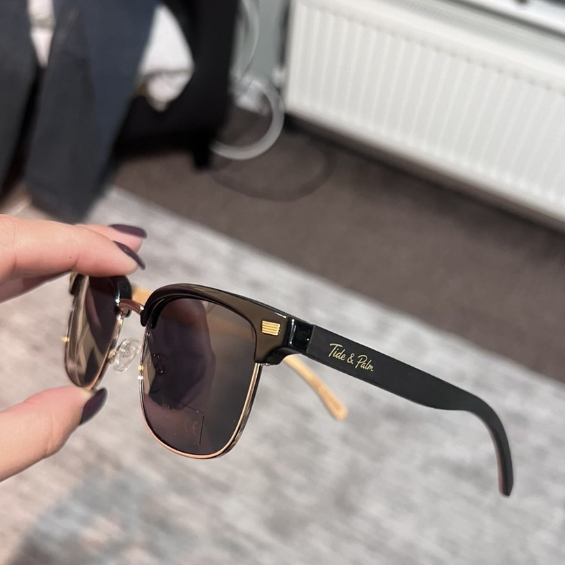 Tide & Palm sunglasses held up by customer Jemma